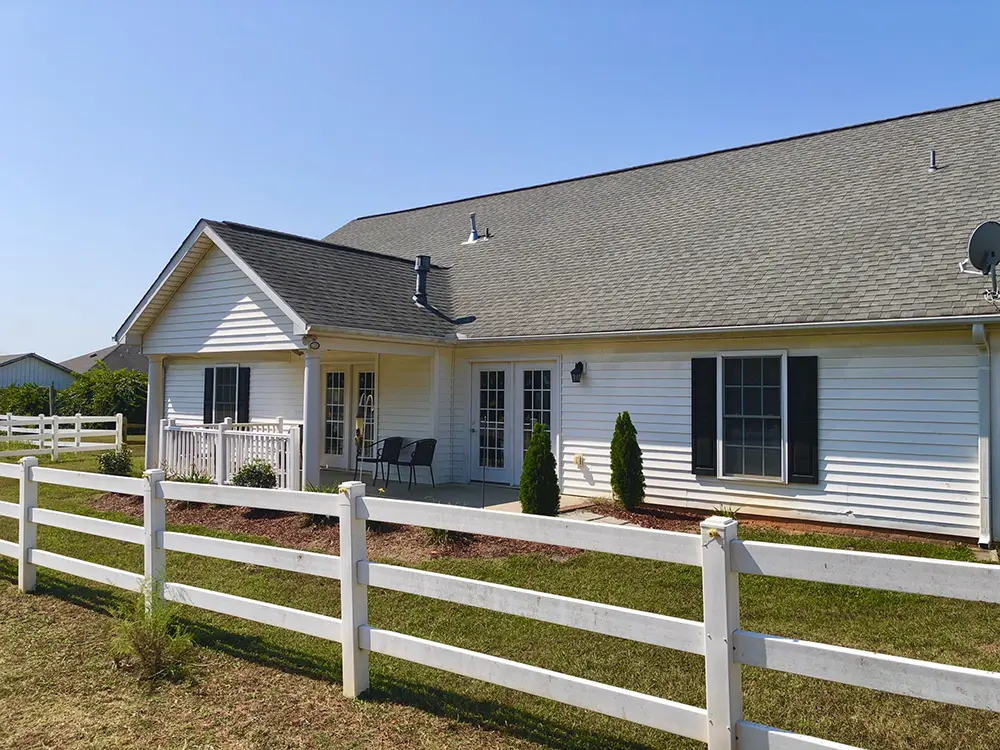 White house with a fenced backyard and patio area